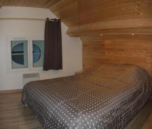 ル・モンドールにあるVilla PRIMEVERE 23の木製の壁のベッドルーム1室(ベッド1台付)