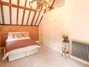 a bedroom with a bed and a brick wall at The Old Barn in Market Rasen