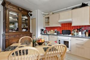 a kitchen with a wooden table with chairs and a tableasteryasteryasteryasteryastery at StayInWoking at 30 Woodlands in Horsell