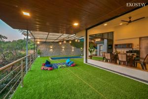 an outdoor patio with green grass and a backyard at EKO STAY - Sky Villa in Lonavala