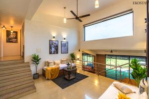 a large living room with a couch and a large window at EKO STAY - Sky Villa in Lonavala