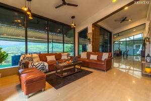 a living room with leather furniture and large windows at EKO STAY - Sky Villa in Lonavala