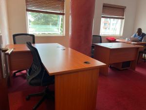 biuro z dwoma biurkami i osoba siedząca przy laptopie w obiekcie Park Place Business Center w mieście Nairobi