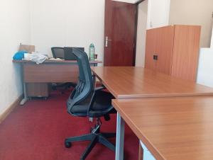 eine Büronische mit einem Schreibtisch und einem schwarzen Stuhl in der Unterkunft Park Place Business Center in Nairobi