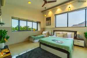 a bedroom with two beds and two windows at EKO STAY - Sky Villa in Lonavala