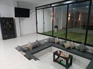 uma sala de estar com um sofá e uma televisão em Casa de campo Jumbo em Laredo Hacienda