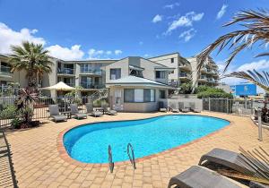 a swimming pool in front of a building at Scarborough Beach Front Resort - Shell Ten in Perth