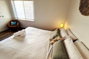 a bedroom with a white bed with a couch at Scarborough Beach Front Resort - Shell Ten in Perth