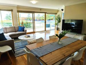 sala de estar con mesa de madera y sofá en Clifton On Scarborough - Absolute Beachfront, en Perth