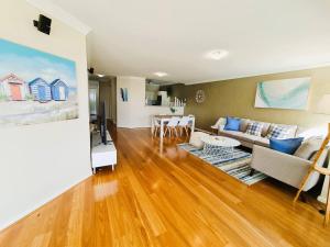 sala de estar con sofá y mesa en Clifton On Scarborough - Absolute Beachfront, en Perth