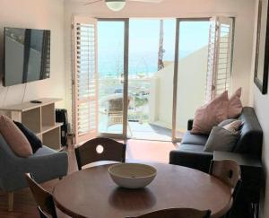 a living room with a table and a couch at Scarborough Beach Front Resort - Shell Thirteen in Perth