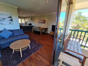 - un salon avec un canapé bleu et une table dans l'établissement Summer Breeze - Holiday Or Business Apartment, à Perth