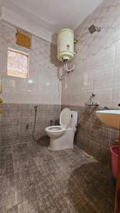 a bathroom with a toilet and a sink at The Suraj lodge, Hadimba Road Manali in Manāli