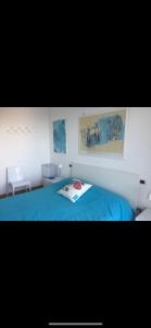 a bedroom with a blue bed with paintings on the wall at Attico Grace Sanremo near the sea in Sanremo