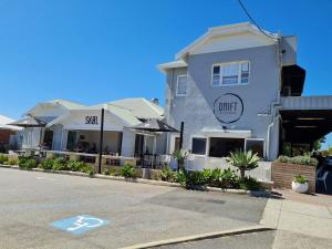 a white building with a cafe on the side of a street at Summer Breeze - Holiday Or Business Apartment in Perth