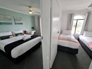 um quarto com 2 camas e uma janela em Chic 2 Bed Apartment On Scarborough Beach em Perth