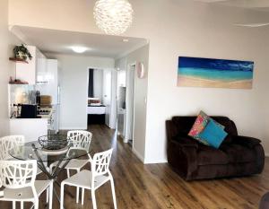 ein Wohnzimmer mit einem Glastisch und einem Sofa in der Unterkunft West Beach Lagoon 123 - Location & Views!!! in Perth