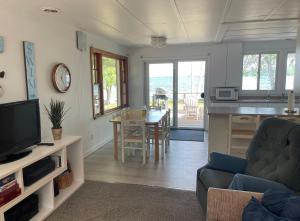 ein Wohnzimmer mit einer Küche und einem Esszimmer in der Unterkunft New! Birch Cove Bungalow - Gorgeous Lakefront! in Honor