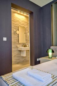 una camera con un letto con lavandino e specchio di Jules Suites a San Giuliano