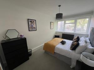 een slaapkamer met een bed, een dressoir en een raam bij Clapham Oasis: Relax & Explore! in Londen