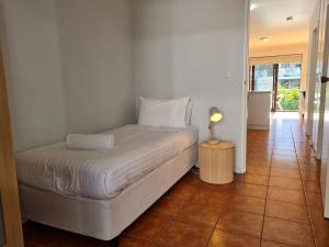 a bedroom with a bed and a lamp on a tiled floor at West Beach Lagoon 204 - Ground Floor! in Perth