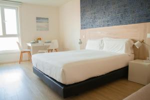 a bedroom with a large bed and a desk at Select Porto Suites in Porto