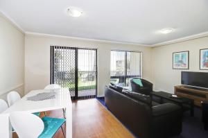 a living room with a couch and a table at West Beach Lagoon 202 - Quiet & Ground Floor! in Perth