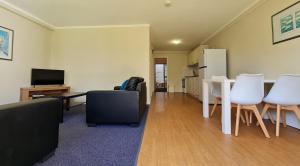 een woonkamer met een tafel en witte stoelen bij West Beach Lagoon 202 - Quiet & Ground Floor! in Perth