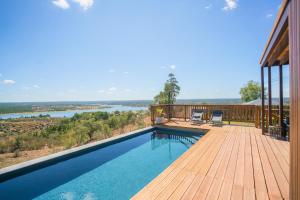 a pool on a deck with a view of a river at Caju Villas Montargil - Villa Vale Vilão in Montargil