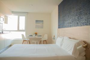 a bedroom with a white bed and a table at Select Porto Suites in Porto +31 photos