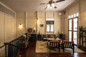 een woonkamer met een bank en een plafondventilator bij Wallaya Heritage Stay in Bangkok