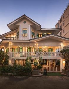 een groot gebouw met een veranda en een balkon bij Wallaya Heritage Stay in Bangkok