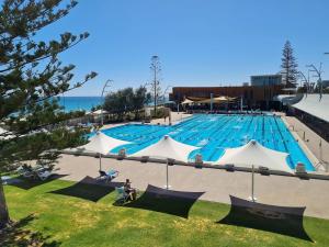 a large swimming pool with blue water at West Beach Lagoon 206 Ground Floor 2mins beach in Perth