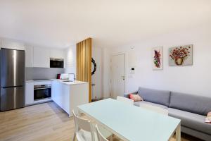 eine Küche und ein Wohnzimmer mit einem Sofa und einem Tisch in der Unterkunft Zona Hospitales y Clinica Universitaria - TuApartamento in Pamplona