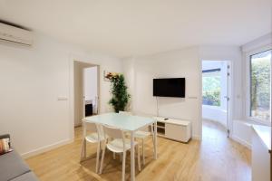 sala de estar blanca con mesa y TV en Zona Hospitales y Clinica Universitaria - TuApartamento en Pamplona