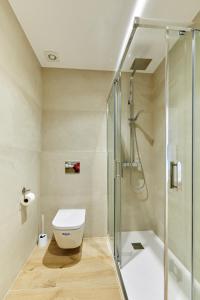 a bathroom with a toilet and a glass shower at Zona Hospitales y Clinica Universitaria - TuApartamento in Pamplona