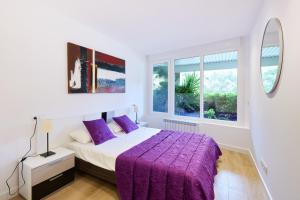 ein Schlafzimmer mit einem lila Bett und einem Fenster in der Unterkunft Zona Hospitales y Clinica Universitaria - TuApartamento in Pamplona