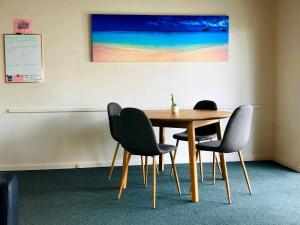 tavolo e sedie in una stanza con parete bianca di West Beach Lagoon 216 - Quiet & Relaxing a Perth