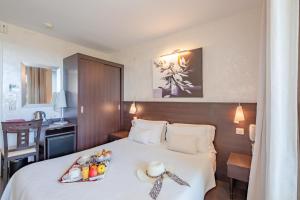 - une chambre d'hôtel avec un lit et un plateau de nourriture dans l'établissement Hôtel La Plage, à Sainte-Maxime
