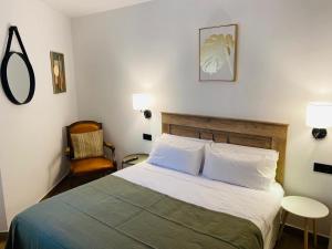 a bedroom with a large bed and a chair at El Parador del César Boutique, Aparcamiento Gratis in Mérida