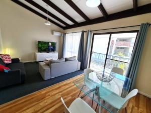 a living room with a glass table and a couch at Seashore Memories - Sleeps 3 in Perth