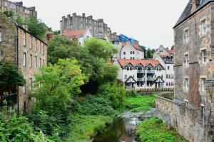 a city with buildings and a river in the foreground at Cosy 2-bedroom house in Leith in Edinburgh