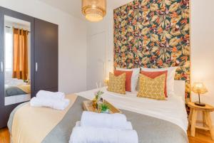 ein Schlafzimmer mit einem großen Bett mit zwei weißen Kissen in der Unterkunft Escale à Nairobi-Portes de Paris-PARKING in Saint-Ouen
