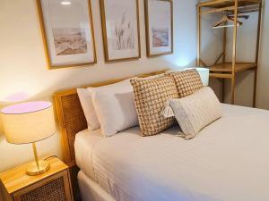 sypialnia z łóżkiem z poduszkami i lampą w obiekcie Beach Break Iconic Scarborough w mieście Perth