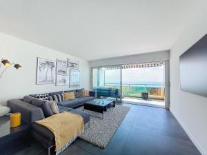 ein Wohnzimmer mit einem Sofa und einem Tisch in der Unterkunft N&J - LE ROYAL LUXEMBOURG - Sea view - Terrace in Nizza