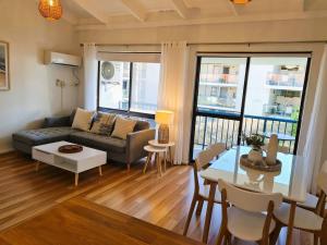 a living room with a couch and a table at Beach Break Iconic Scarborough in Perth