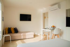 a white living room with a couch and a table at room Select Porto Suites in Porto