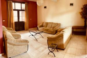 a living room with two couches and two chairs at Évasion Urbaine: Charme & Confort à Bujumbura in Bujumbura