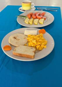 two plates of breakfast food on a blue table at Hotel Playa Divina in Coveñas
