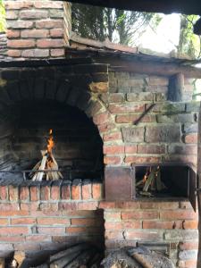 an open brick oven with a fire in it at Будинки рибалки in Sudovaya Vishnya